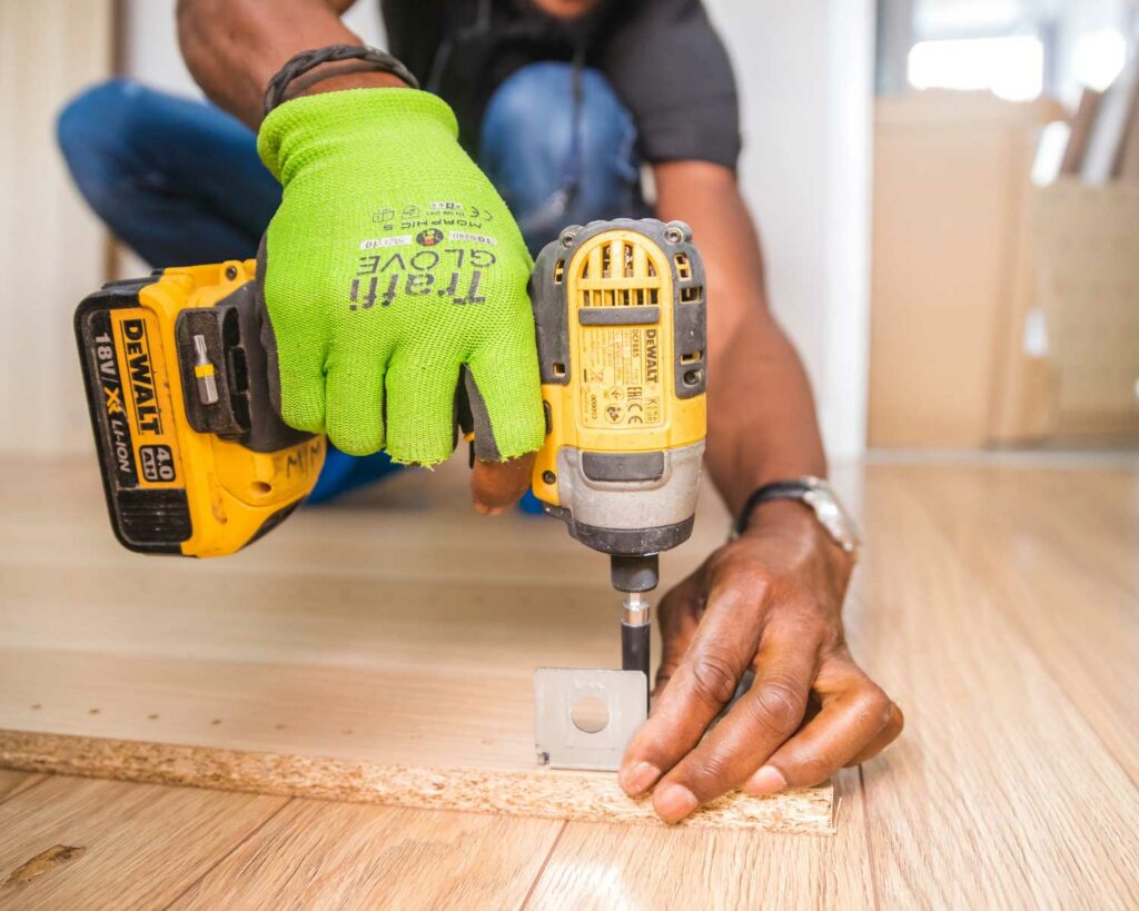 Close up of worker drilling in latches to wood using drill