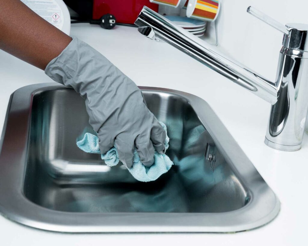 Close up of someone cleaning kitchen sink